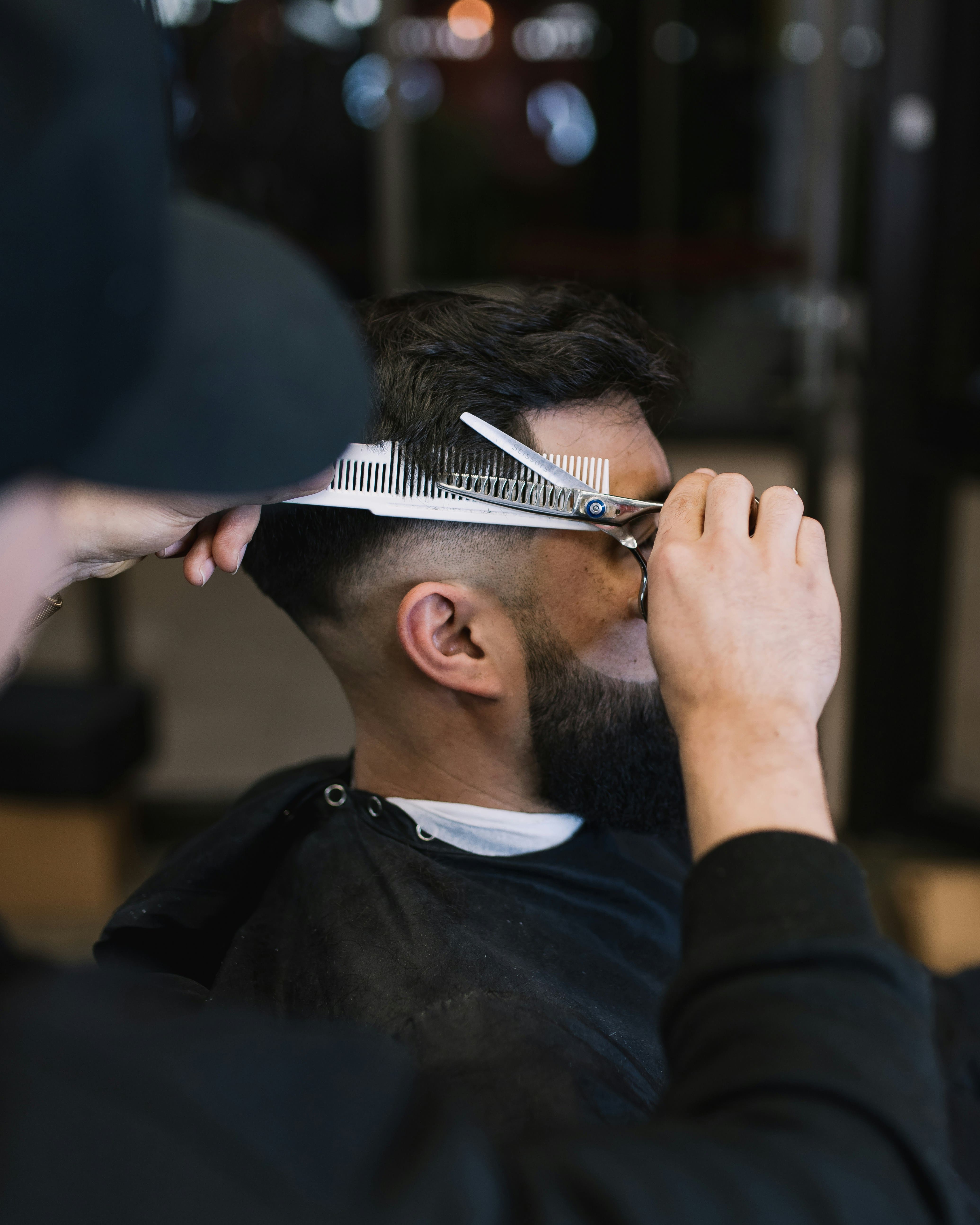 Barbero cortando el cabello de un cliente